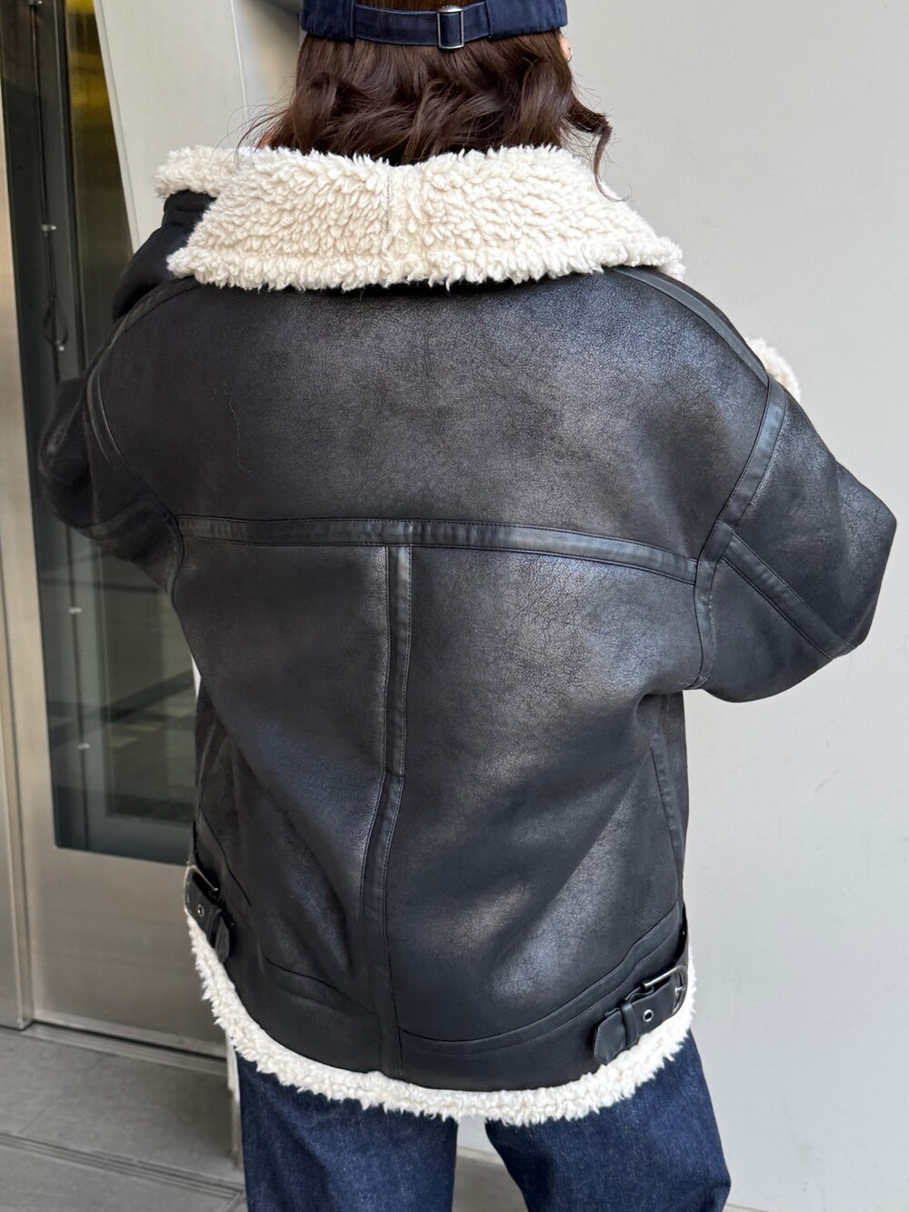 ブルー系のデニムパンツ、ホワイト系のカーディガン/ボレロ、ブラック系のブルゾンを着用したレディースの冬コーディネートの10枚目の写真