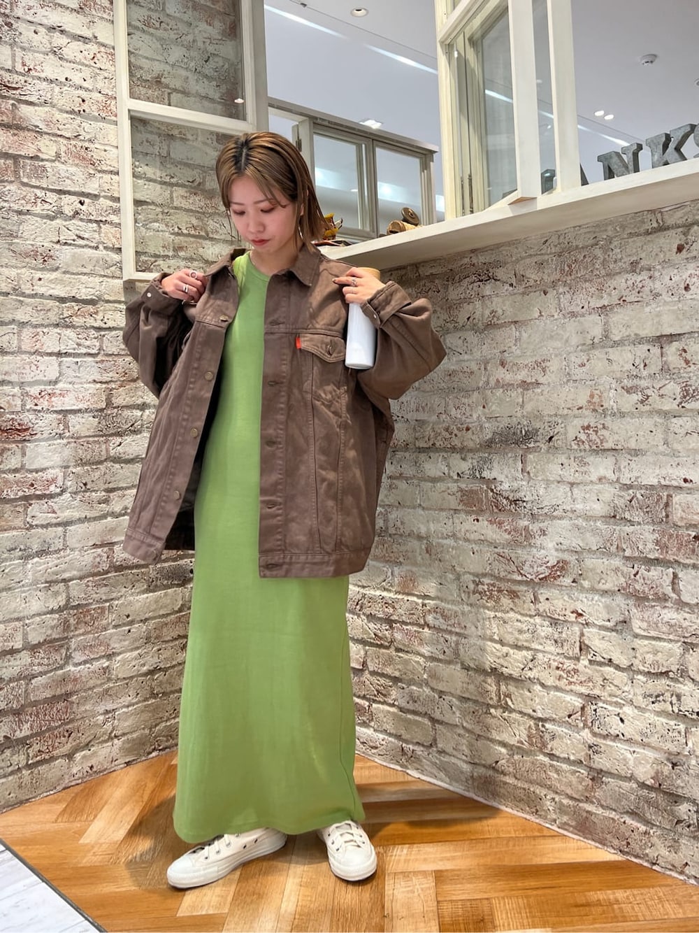 ブラウン系のデニムジャケット、グリーン系のワンピースを着用したレディースの夏コーディネートの3枚目の写真