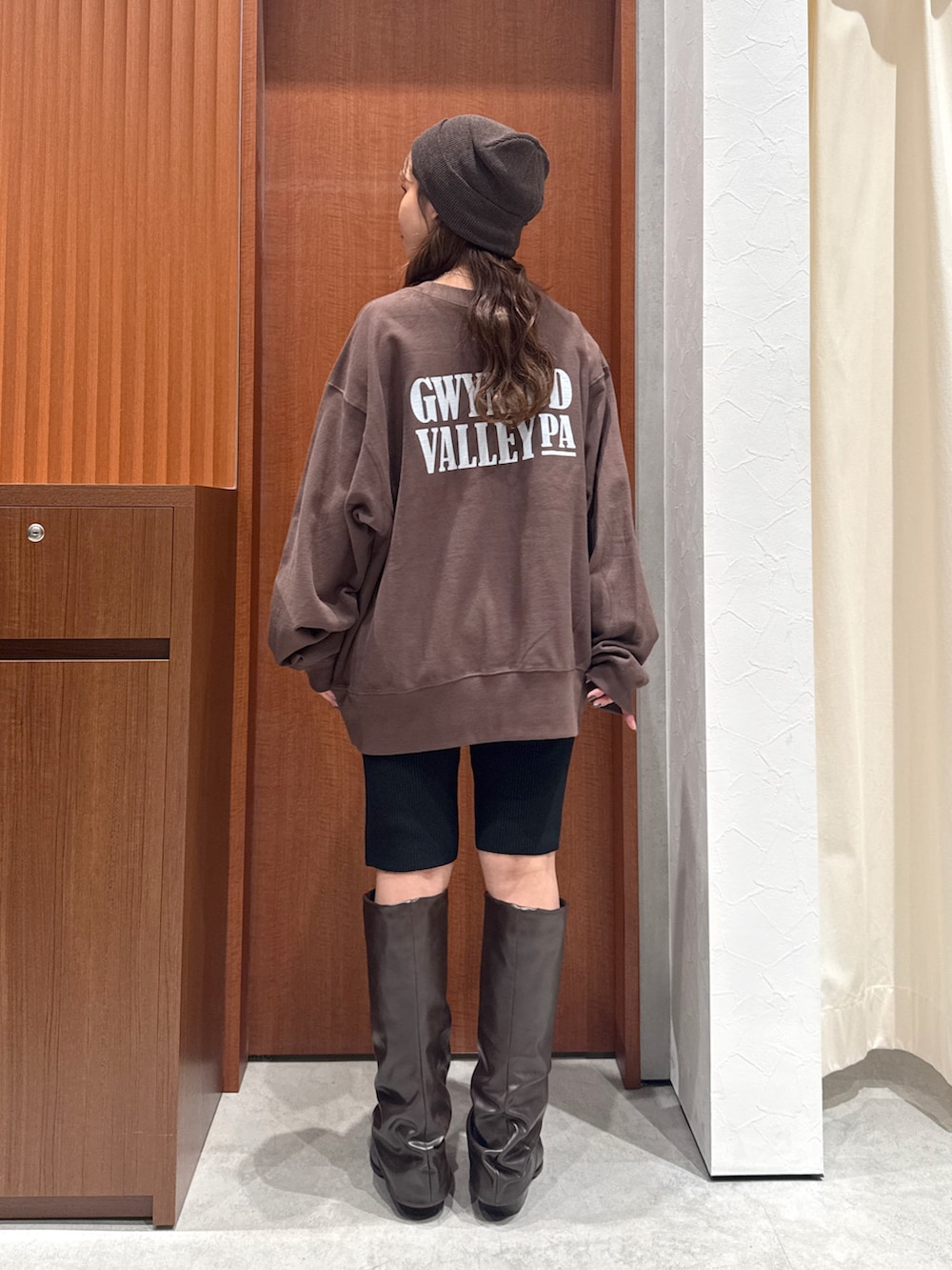 ベージュ系のトレンチコート、ブラウン系のスウェット、ブラック系のその他パンツを着用したレディースの秋コーディネートの9枚目の写真