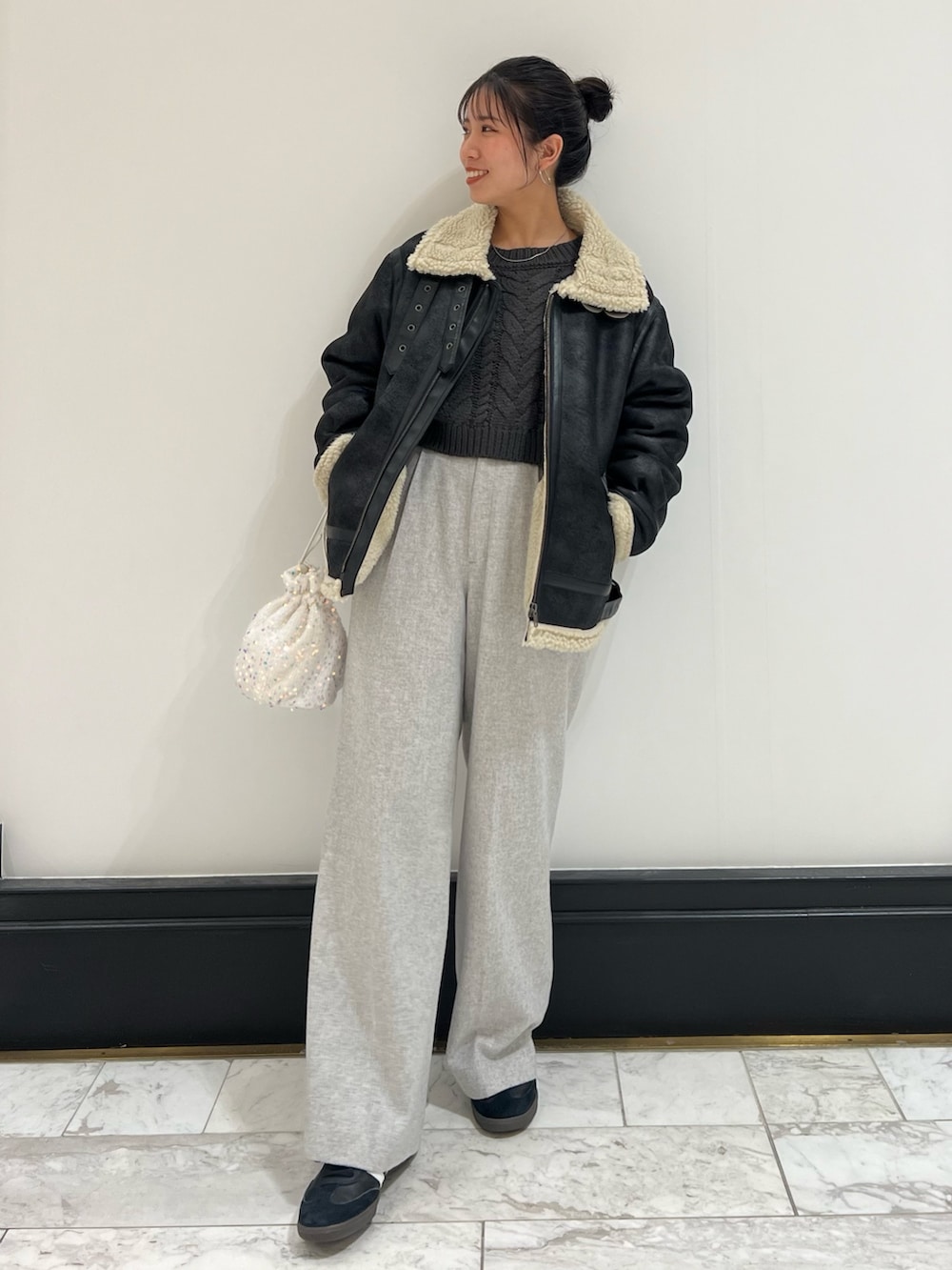ホワイト系のハンドバッグ、グレー系のニット/セーター、ブラック系のムートンコートを着用したレディースの冬コーディネートの8枚目の写真