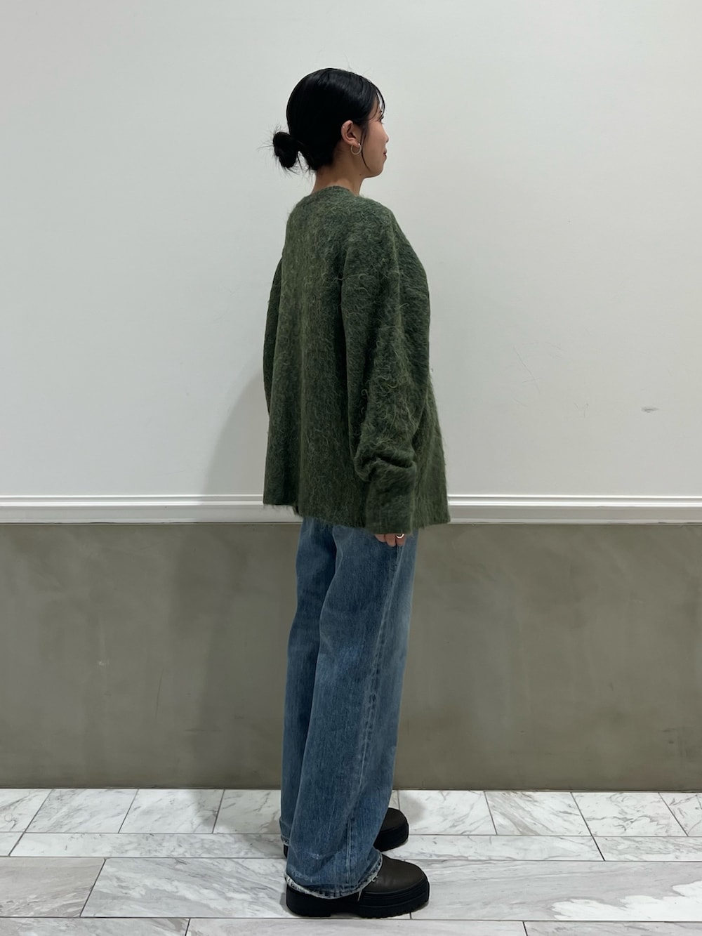 ブルー系のデニムパンツ、グリーン系のカーディガン/ボレロを着用したレディースの秋コーディネートの5枚目の写真