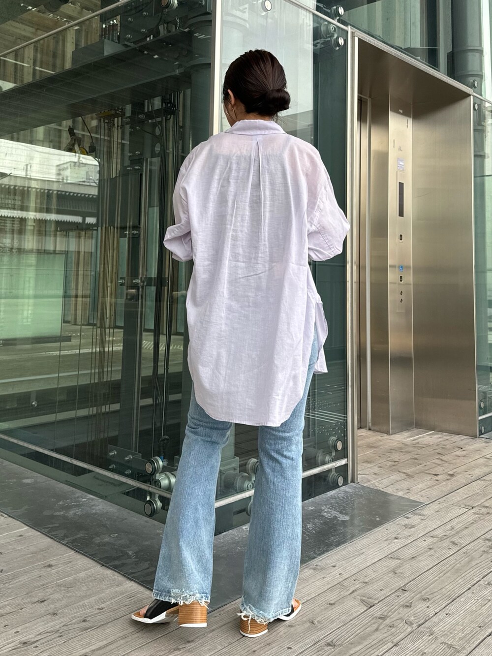 グレー系のTシャツ/カットソー、ブルー系のデニムパンツ、ブラック系のサンダルを着用したレディースの春コーディネートの4枚目の写真