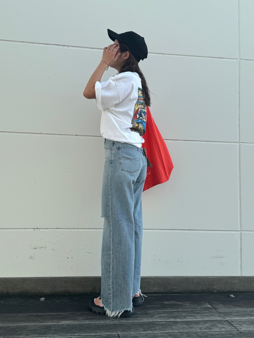 ブルー系のデニムパンツ、ホワイト系のTシャツ/カットソー、オレンジ系のエコバッグ/サブバッグを着用したレディースの夏コーディネートの5枚目の写真