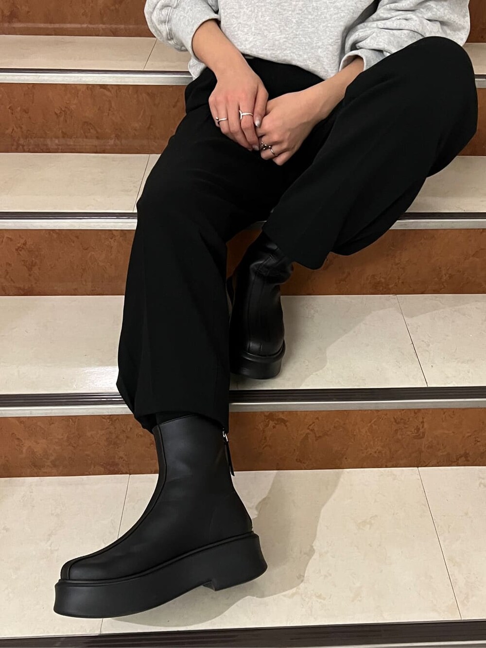 ブラック系のその他パンツ、ブラック系のブーツ、グレー系のスウェットを着用したレディースの冬コーディネートの2枚目の写真