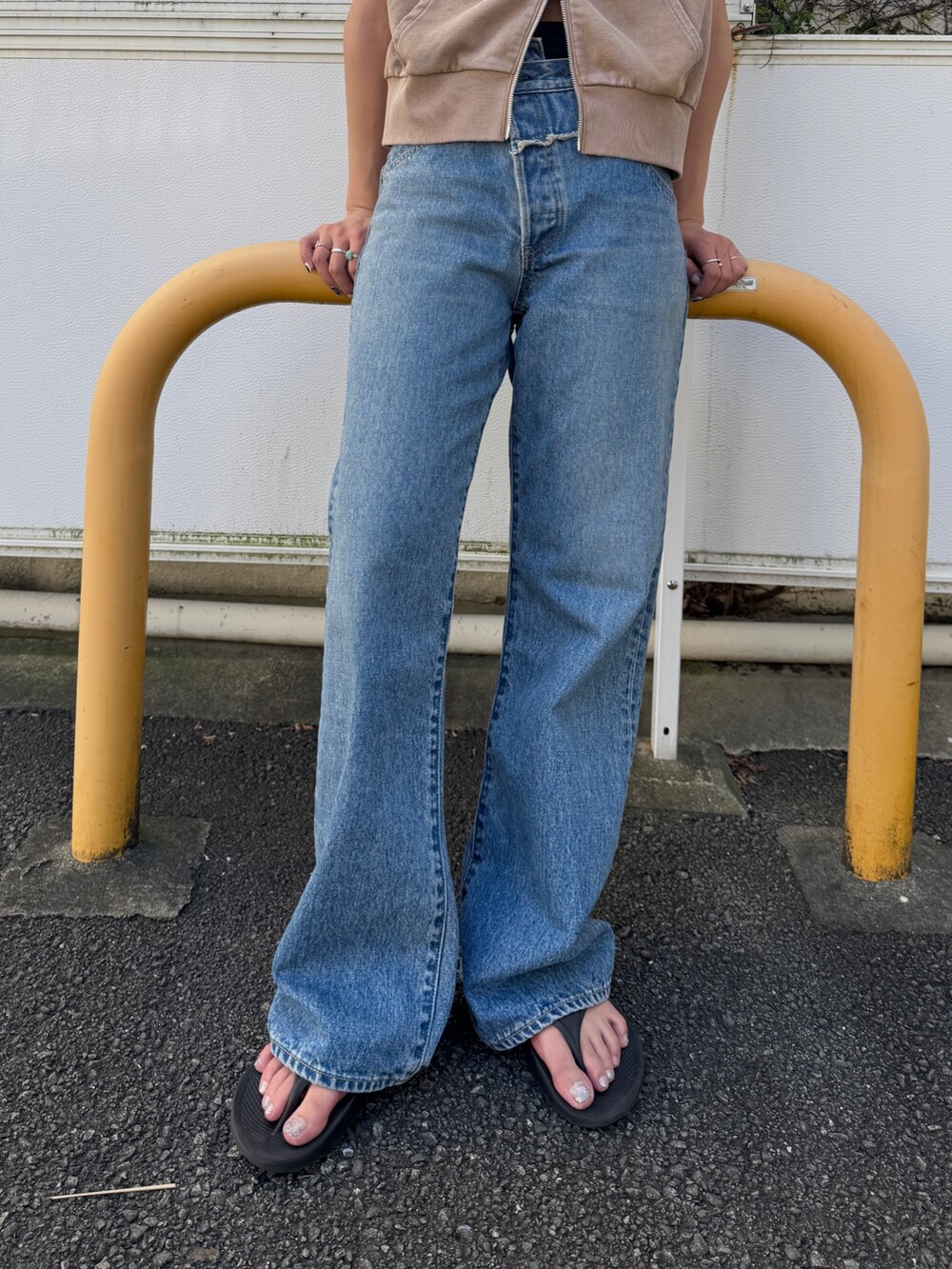 ベージュ系のパーカー、ブルー系のデニムパンツを着用したレディースの夏コーディネートの8枚目の写真