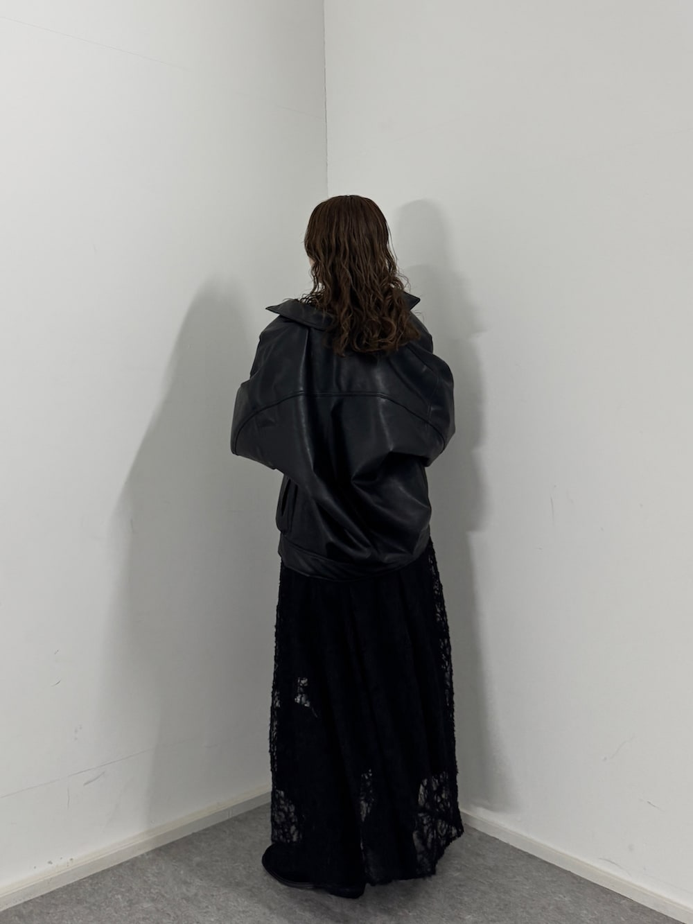 ブラック系のワンピース、ブラック系のブルゾン、ブラック系のブーツを着用したレディースの冬コーディネートの4枚目の写真