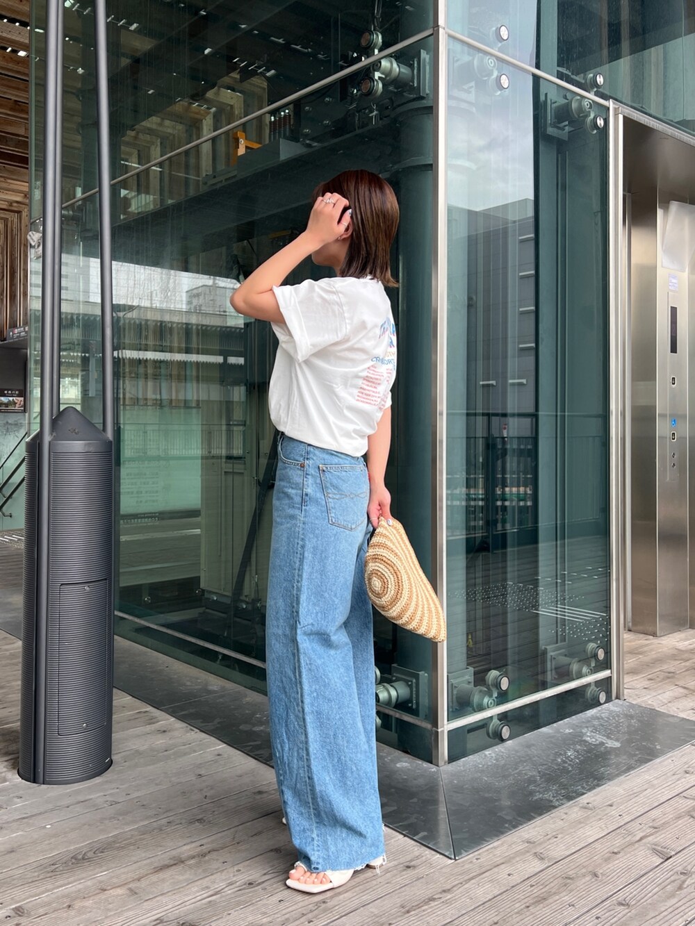 ホワイト系のTシャツ/カットソー、ホワイト系のサンダル、ブルー系のデニムパンツを着用したレディースの春コーディネートの4枚目の写真