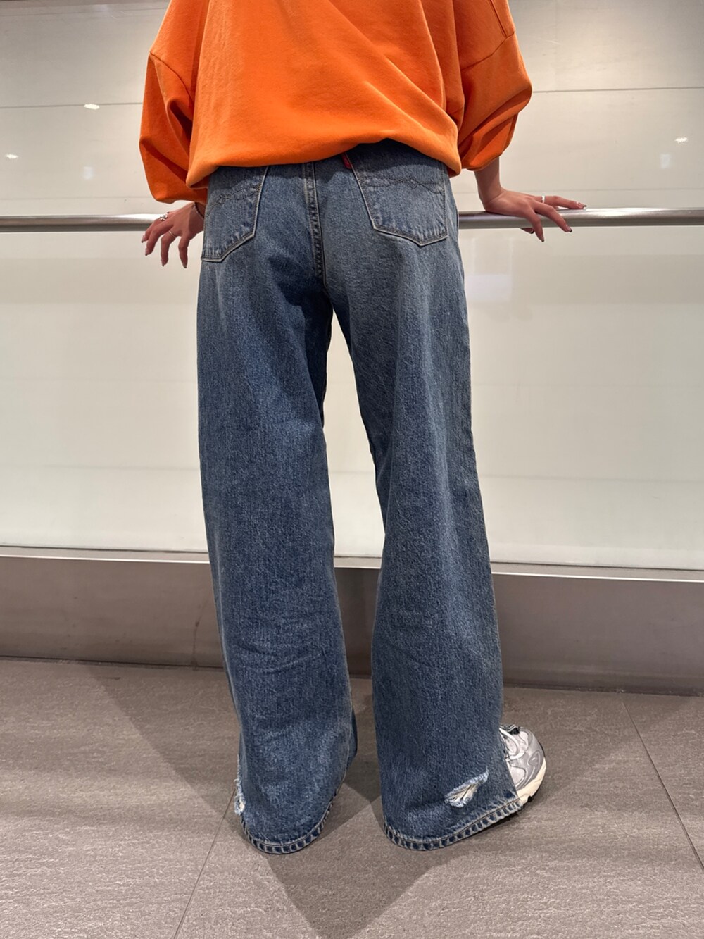 ブルー系のデニムパンツ、オレンジ系のスウェットを着用したレディースの冬コーディネートの9枚目の写真