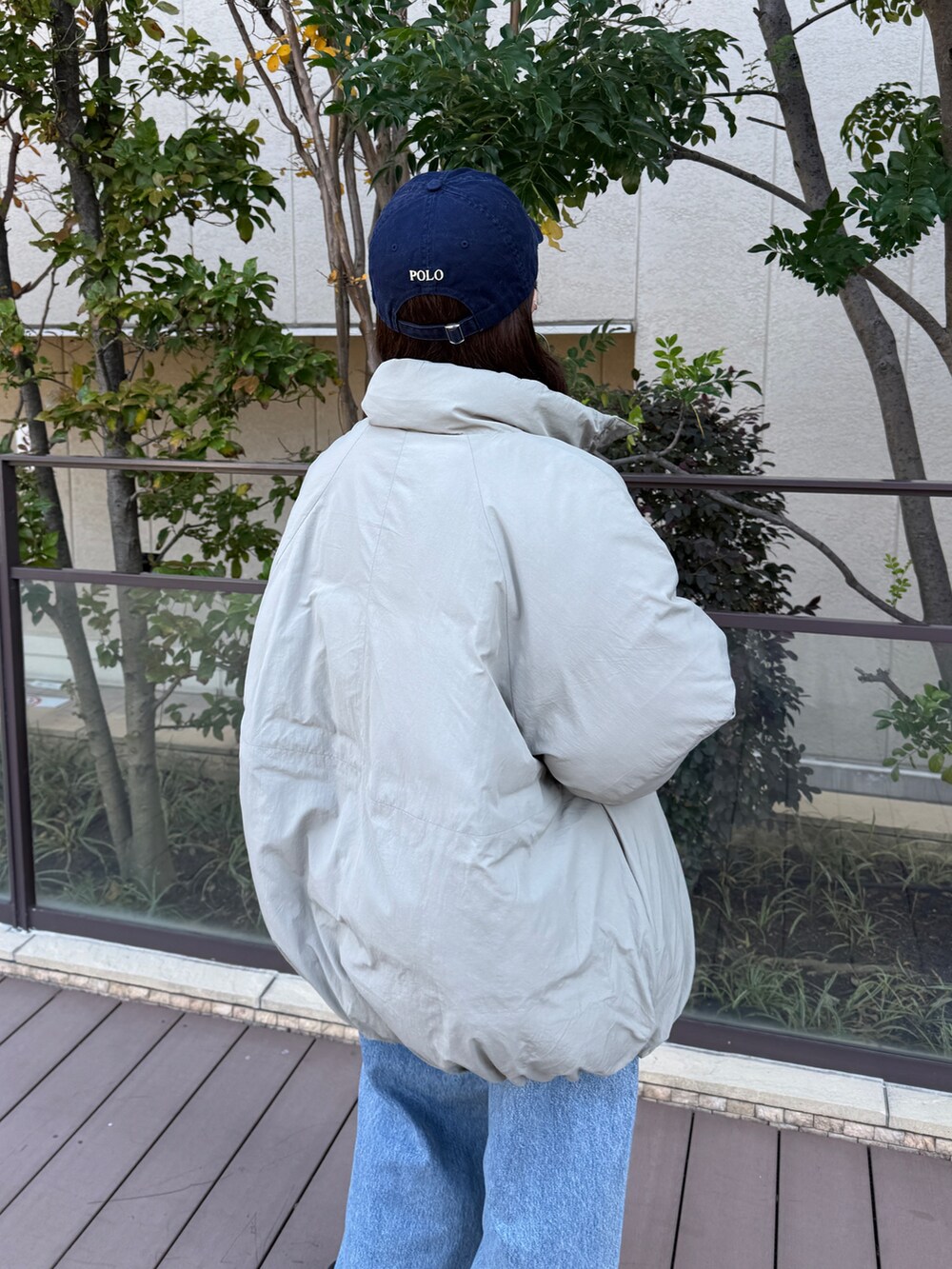 ベージュ系のブルゾン、グレー系のスウェット、ブルー系のデニムパンツを着用したレディースの冬コーディネートの4枚目の写真