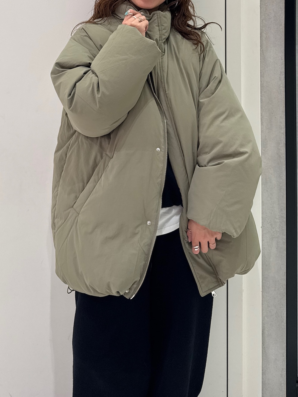 ブラック系のニット/セーター、ホワイト系のTシャツ/カットソー、ブラック系のその他パンツを着用したレディースの冬コーディネートの8枚目の写真