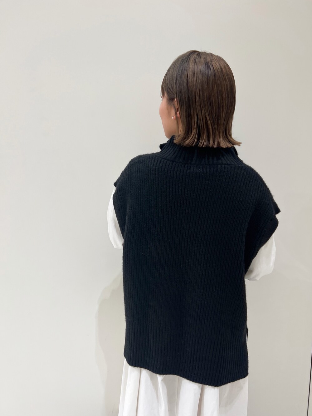 ブラック系のニット/セーター、ブラック系のワンピース、ブラック系のブーツを着用したレディースの冬コーディネートの7枚目の写真