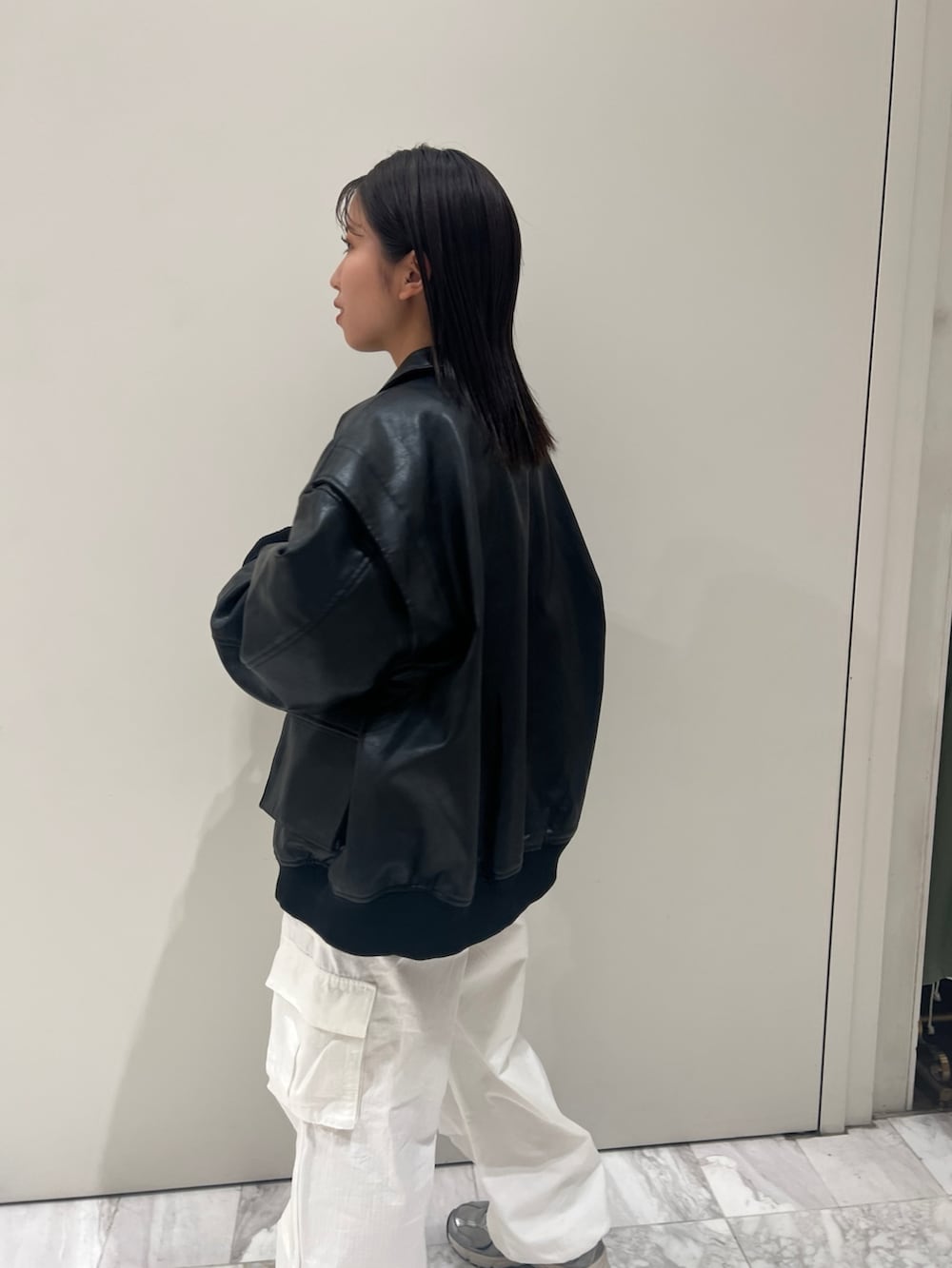 グレー系のニット/セーター、ホワイト系のカーゴパンツ、ブラック系のブルゾンを着用したレディースの秋コーディネートの5枚目の写真