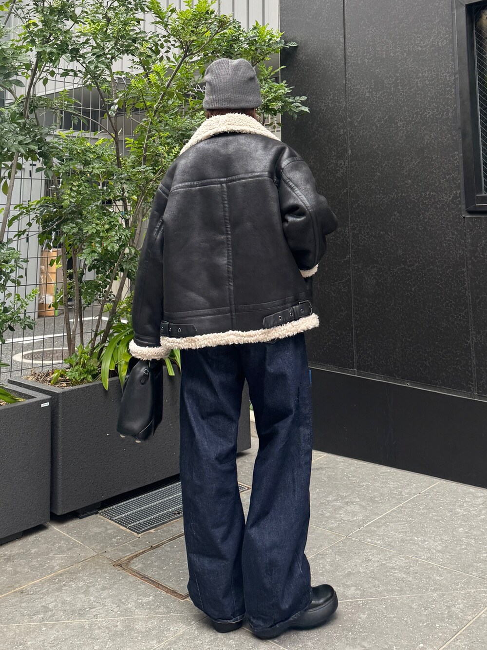 ブラック系のブルゾン、ブルー系のデニムパンツ、グレー系のニット/セーターを着用したレディースの秋コーディネートの8枚目の写真