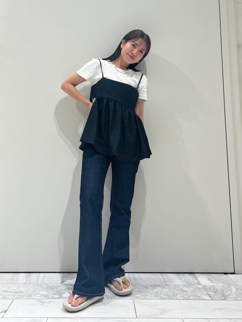 ブルー系のデニムパンツ、ブラック系のキャミソール、ホワイト系のTシャツ/カットソーを着用したレディースの夏コーディネートの2枚目の写真