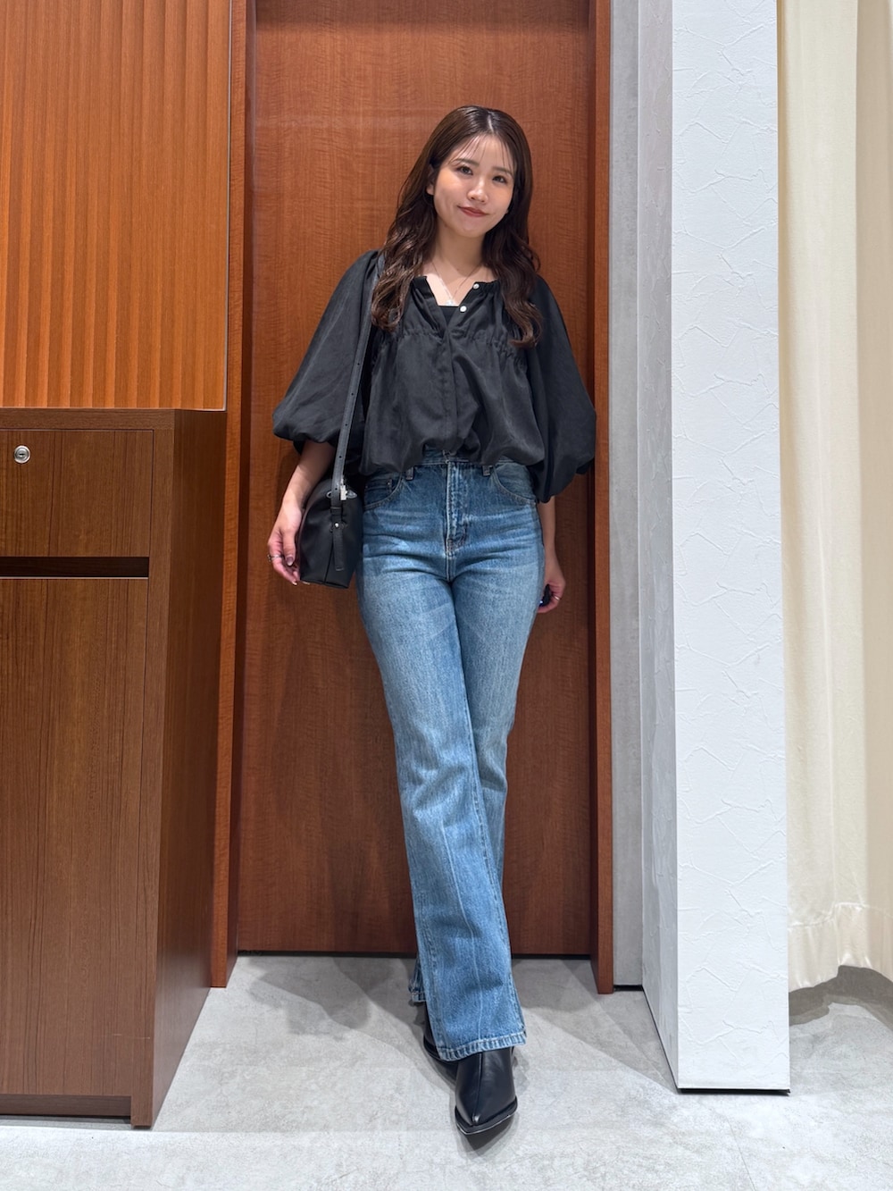 ブルー系のデニムパンツ、ブラウン系のシャツ/ブラウス、ブラック系のハンドバッグを着用したレディースの夏コーディネートの2枚目の写真