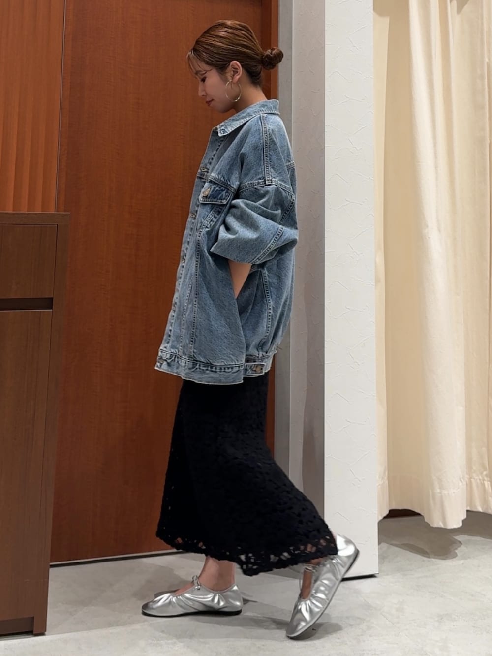 ブラック系のワンピース、ブラック系のTシャツ/カットソー、ブルー系のデニムジャケットを着用したレディースの春コーディネートの3枚目の写真