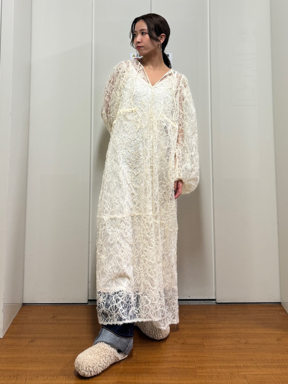 ベージュ系のブルゾン、ホワイト系のワンピース、ブルー系のデニムパンツを着用したレディースの冬コーディネートの7枚目の写真