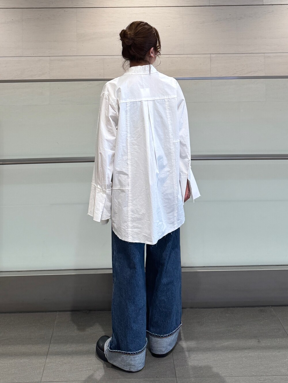 ブルー系のデニムパンツ、ホワイト系のシャツ/ブラウス、ブラック系のシャツ/ブラウスを着用したレディースの冬コーディネートの4枚目の写真