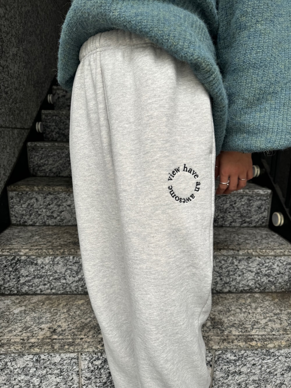 ブラック系のTシャツ/カットソー、グレー系のスウェットパンツ、ブルー系のニット/セーターを着用したレディースの秋コーディネートの9枚目の写真