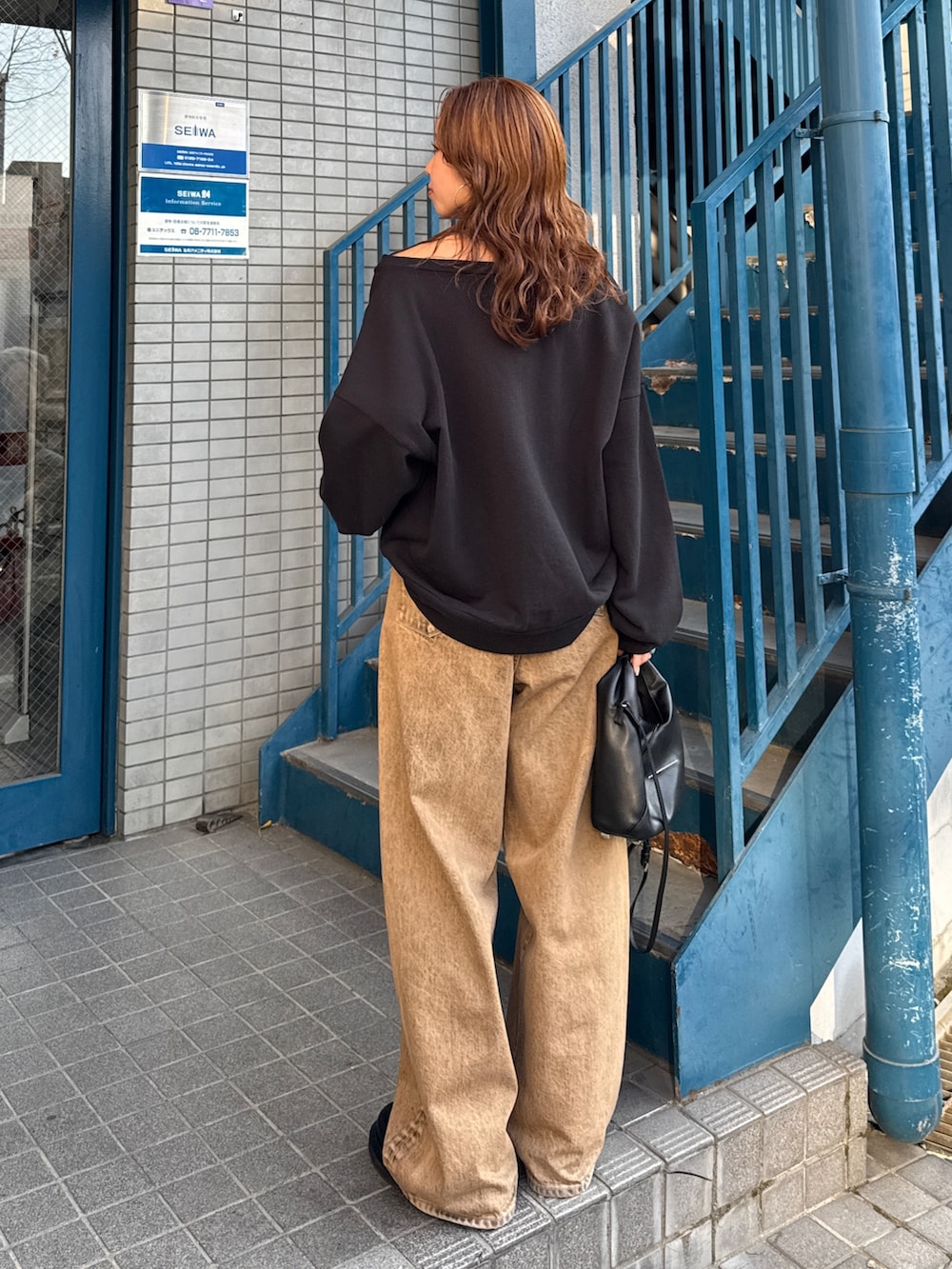 ブラウン系のデニムパンツ、ブラック系のスウェットを着用したレディースの冬コーディネートの5枚目の写真