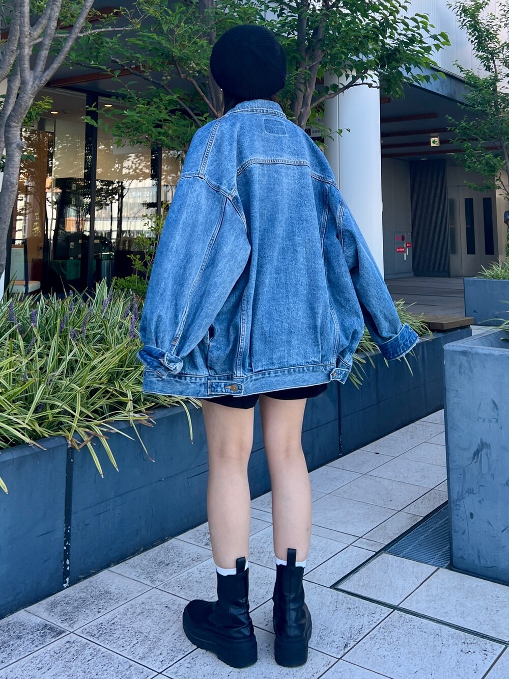 ブルー系のスウェット、ブルー系のデニムジャケット、ブラック系のハンチング/ベレー帽を着用したレディースの秋コーディネートの3枚目の写真