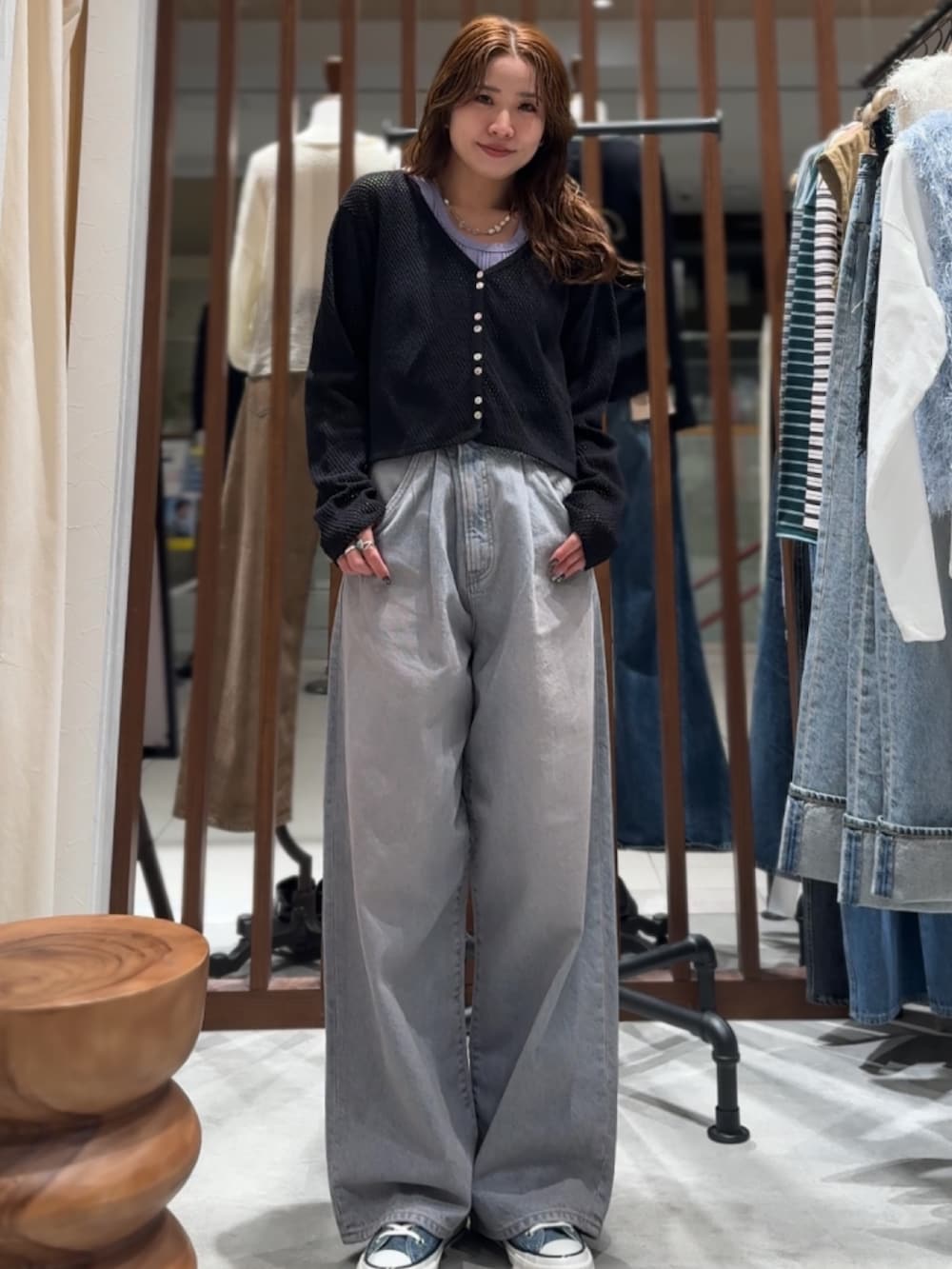 ブルー系のデニムパンツ、ブラック系のカーディガン/ボレロ、パープル系のTシャツ/カットソーを着用したレディースの春コーディネートの7枚目の写真