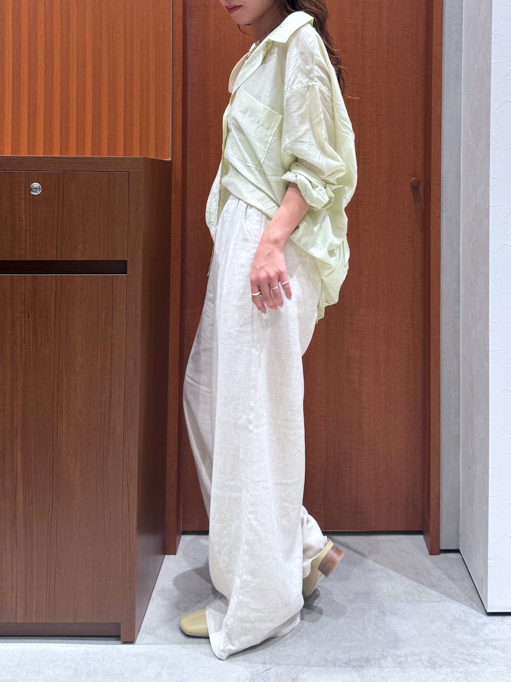 ホワイト系のその他パンツ、グリーン系のシャツ/ブラウス、イエロー系のサンダルを着用したレディースの夏コーディネートの2枚目の写真