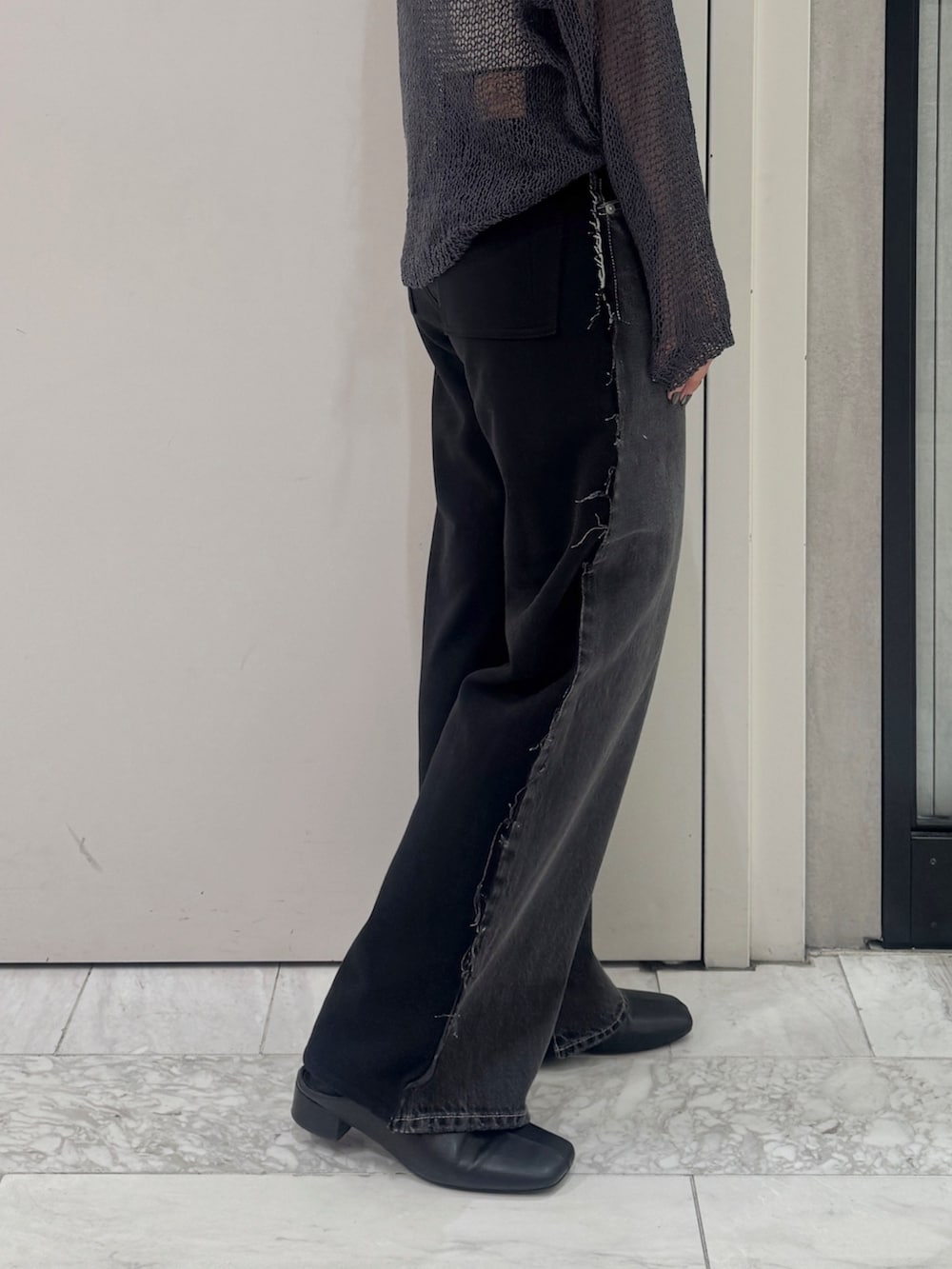 ブラック系のデニムパンツ、グレー系のニット/セーター、ブラック系のサンダルを着用したレディースの秋コーディネートの4枚目の写真