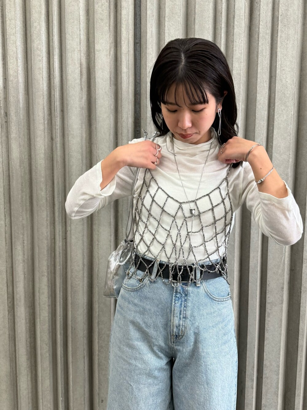 ブラック系のベスト、ブルー系のデニムパンツ、ホワイト系のTシャツ/カットソーを着用したレディースの冬コーディネートの8枚目の写真