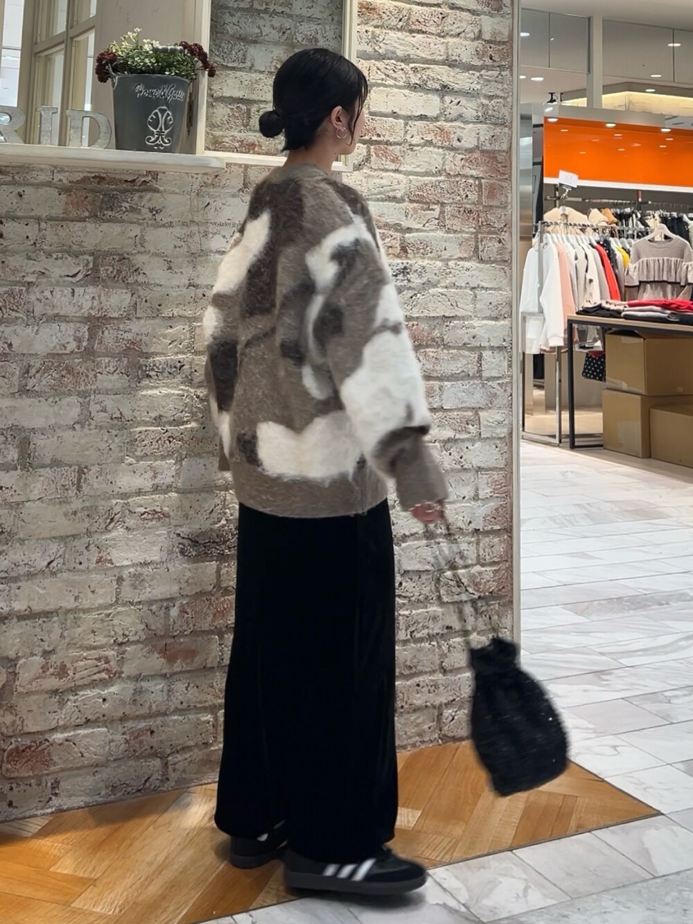 ブラック系のスカート、ブラック系のハンドバッグ、ベージュ系のニット/セーターを着用したレディースの秋コーディネートの7枚目の写真