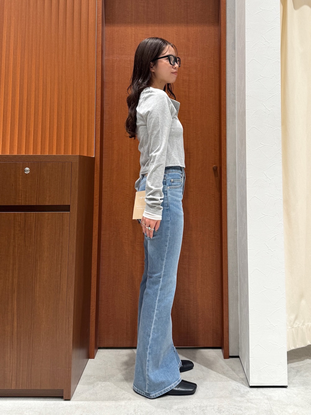 ブルー系のデニムパンツ、ブラック系のサンダル、グレー系のTシャツ/カットソーを着用したレディースの秋コーディネートの6枚目の写真