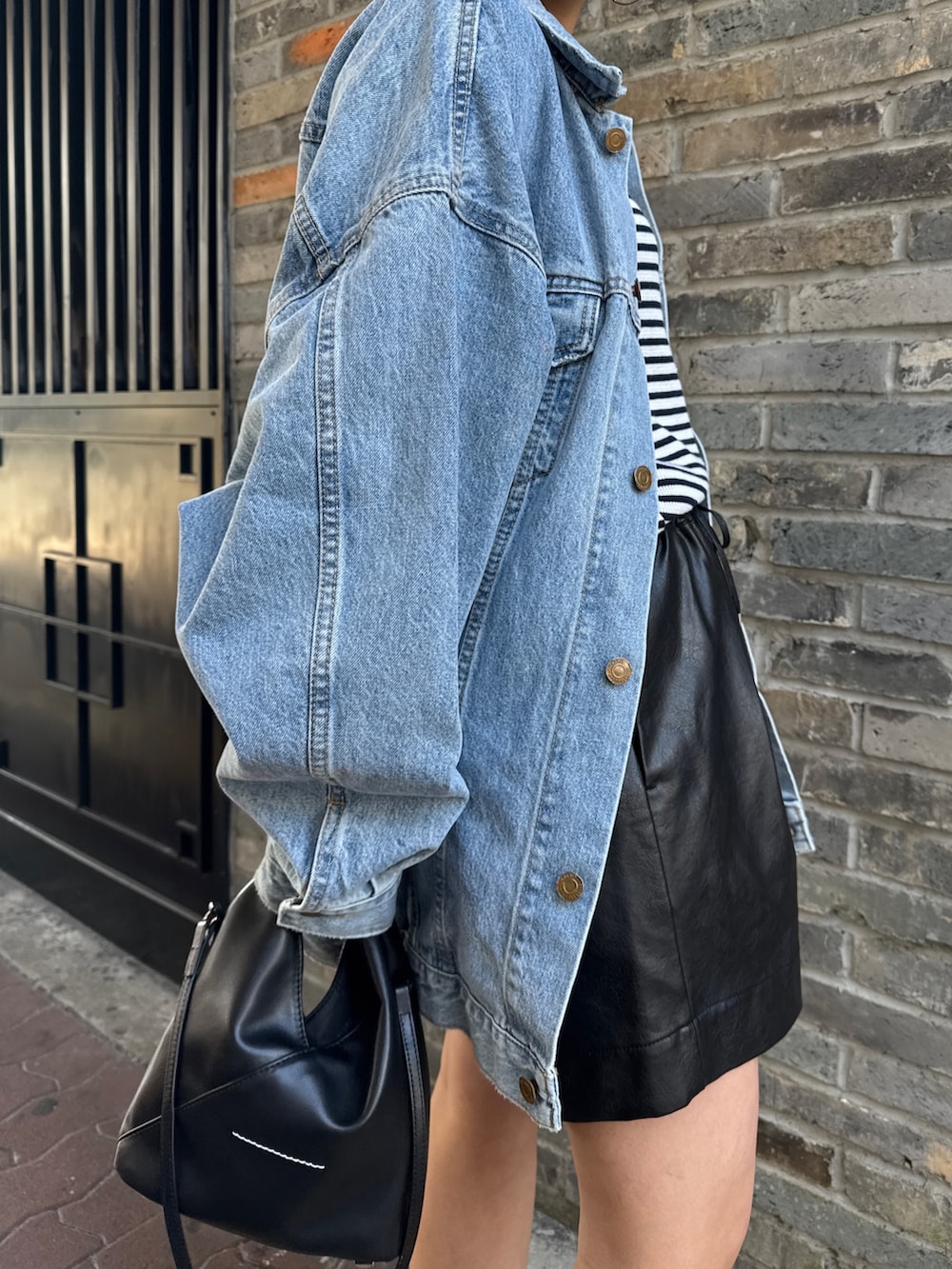 ブルー系のデニムジャケット、ブルー系のTシャツ/カットソー、ブラック系のその他パンツを着用したレディースの冬コーディネートの10枚目の写真