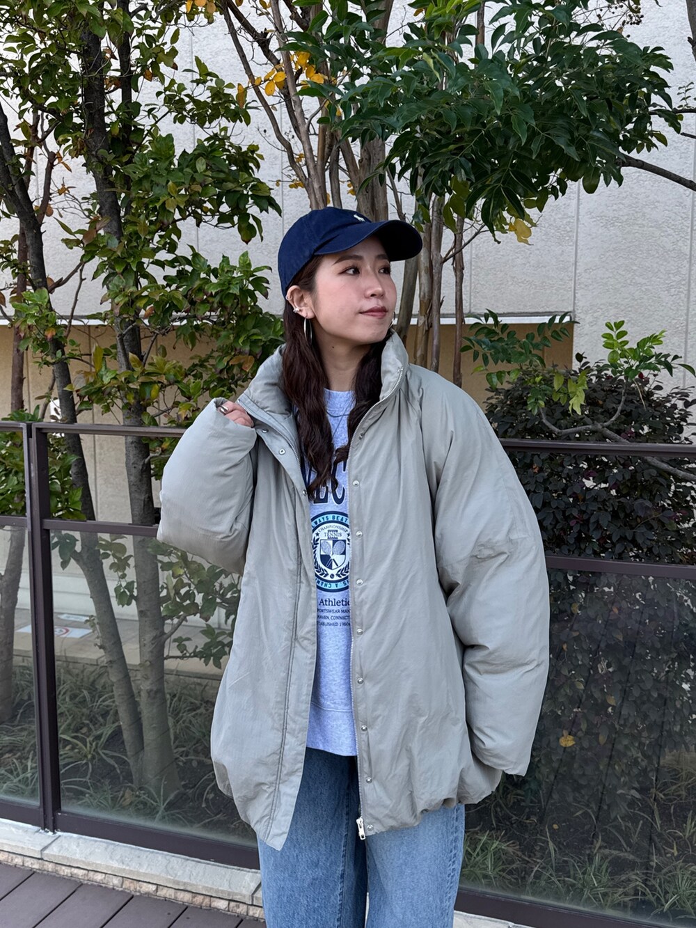 ベージュ系のブルゾン、グレー系のスウェット、ブルー系のデニムパンツを着用したレディースの冬コーディネートの5枚目の写真