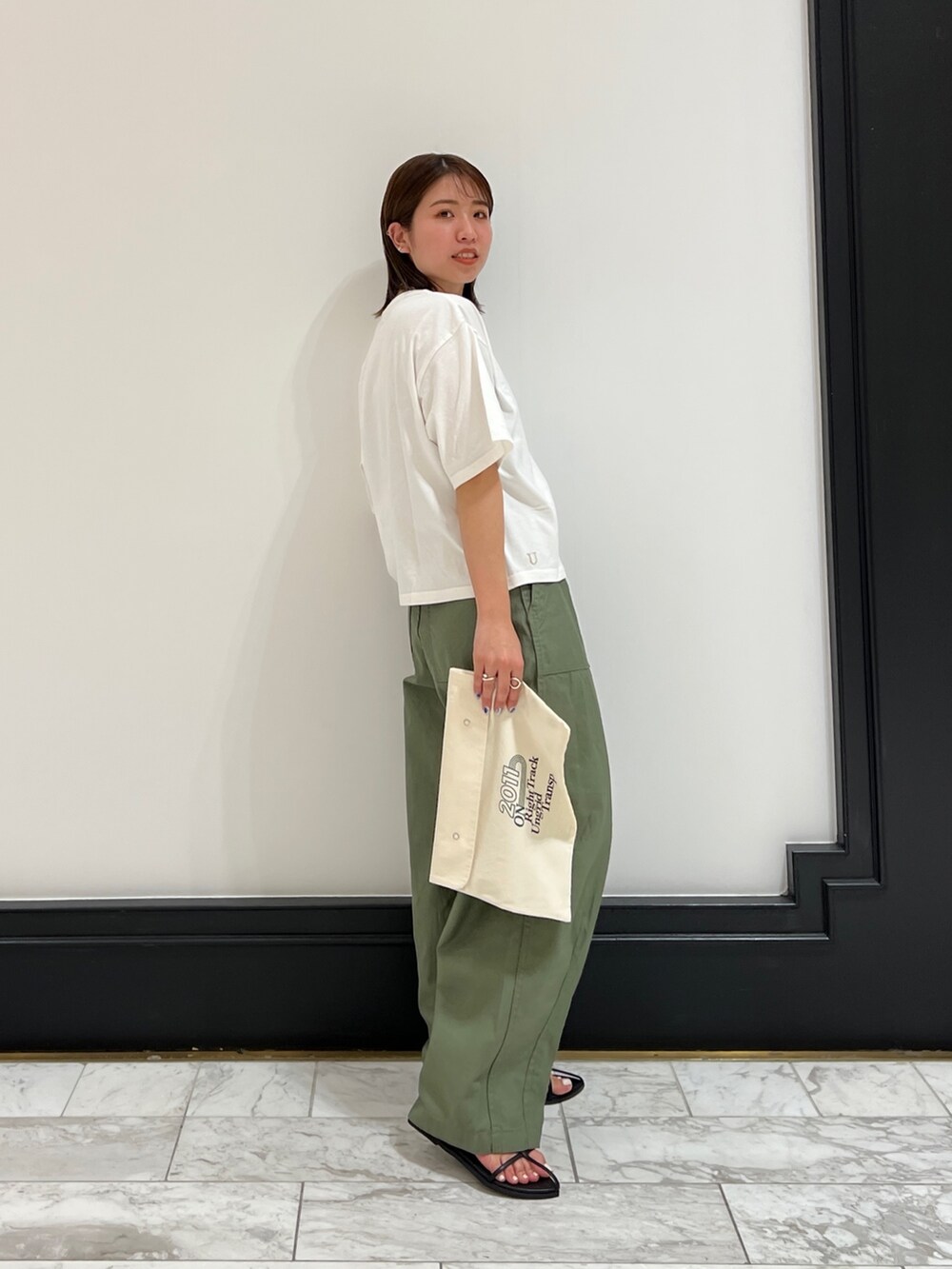 ベージュ系のその他パンツ、ブラック系のサンダル、イエロー系のネックレスを着用したレディースの春コーディネートの5枚目の写真