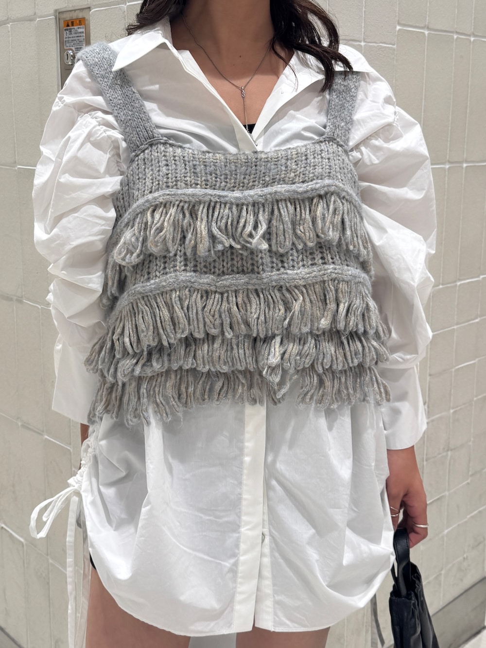 ホワイト系のシャツ/ブラウス、ブルー系のニット/セーター、ブラック系のショルダーバッグを着用したレディースの秋コーディネートの7枚目の写真