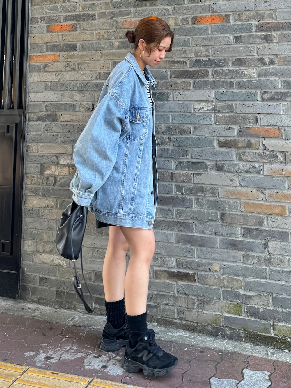 ブルー系のデニムジャケット、ブルー系のTシャツ/カットソー、ブラック系のその他パンツを着用したレディースの冬コーディネートの3枚目の写真