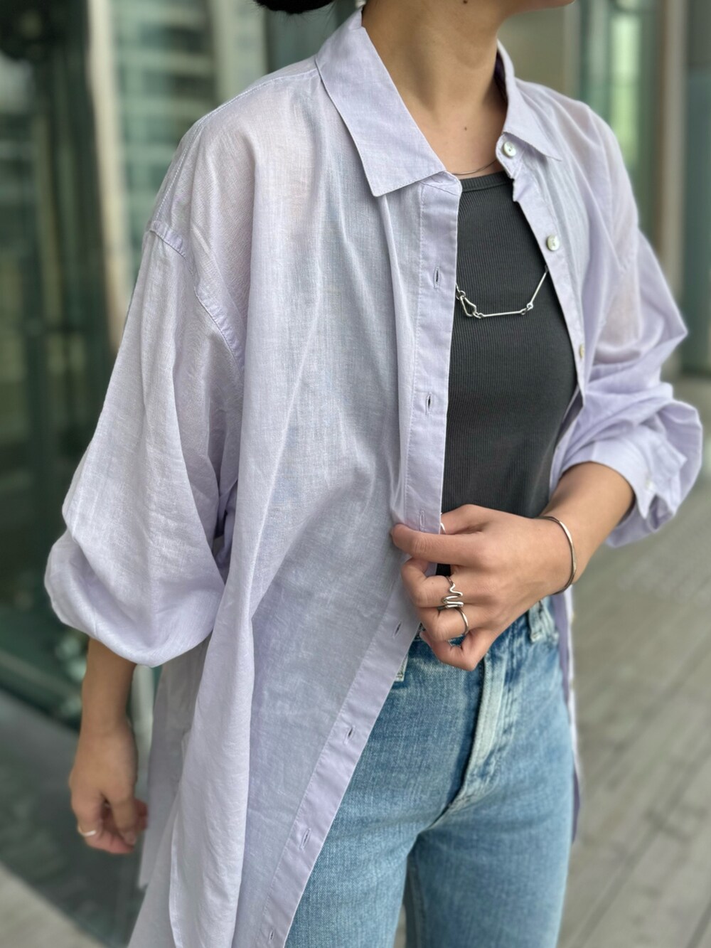 グレー系のTシャツ/カットソー、ブルー系のデニムパンツ、ブラック系のサンダルを着用したレディースの春コーディネートの7枚目の写真