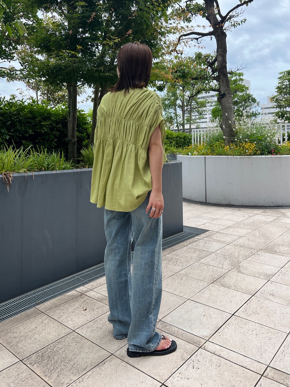 グリーン系のシャツ/ブラウス、ブラック系のキャミソール、ブルー系のデニムパンツを着用したレディースの夏コーディネートの6枚目の写真