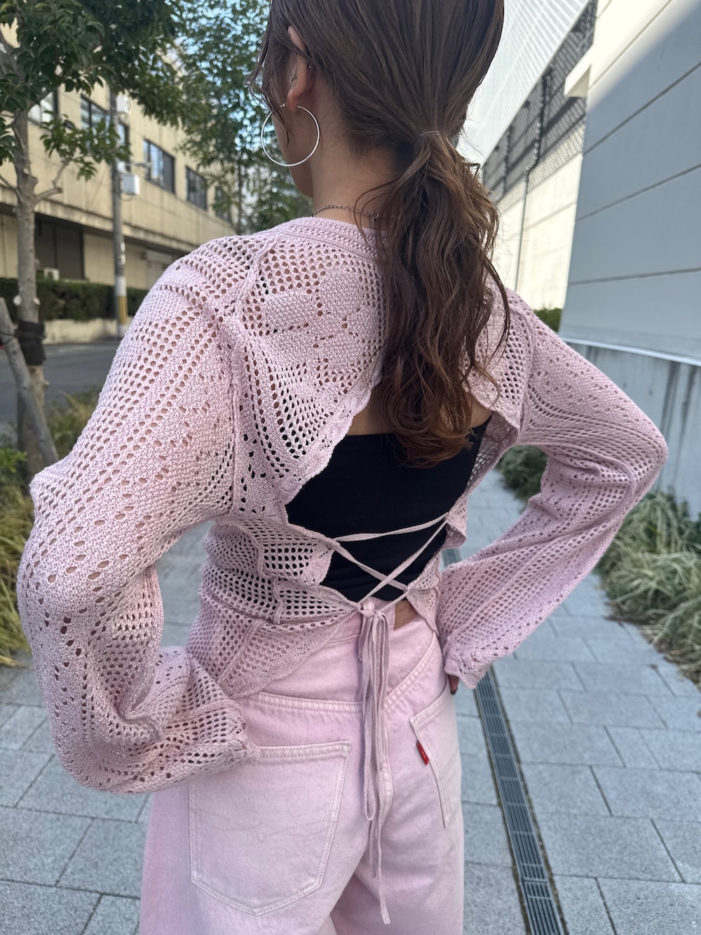 ピンク系のデニムパンツ、ピンク系のニット/セーター、ブラック系のパンプスを着用したレディースの春コーディネートの8枚目の写真