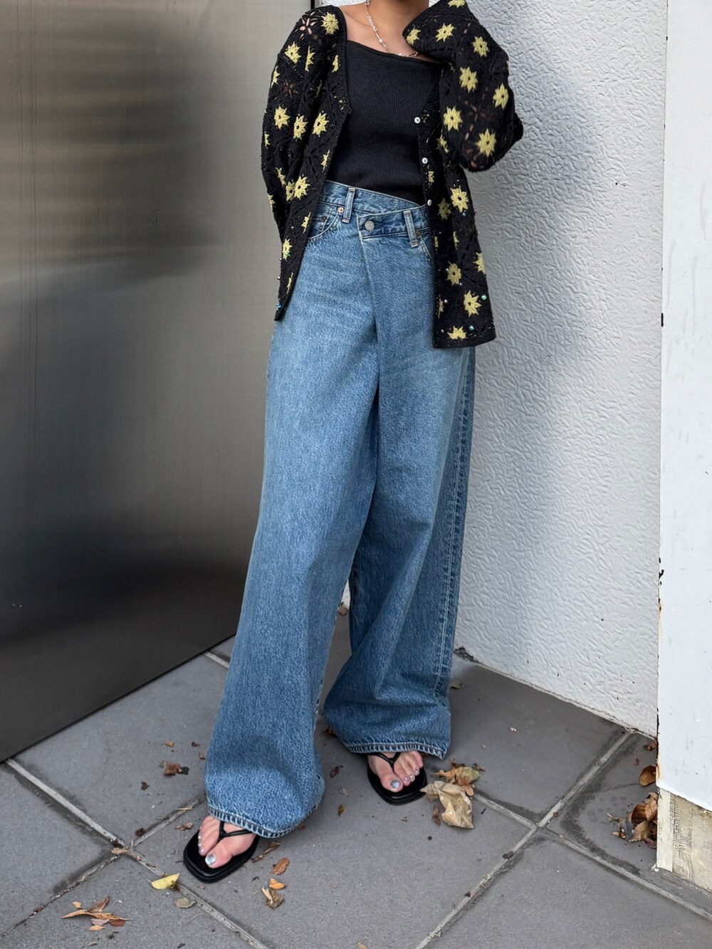 グレー系のカーディガン/ボレロ、ブルー系のデニムパンツ、ブラック系のサンダルを着用したレディースの春コーディネートの2枚目の写真