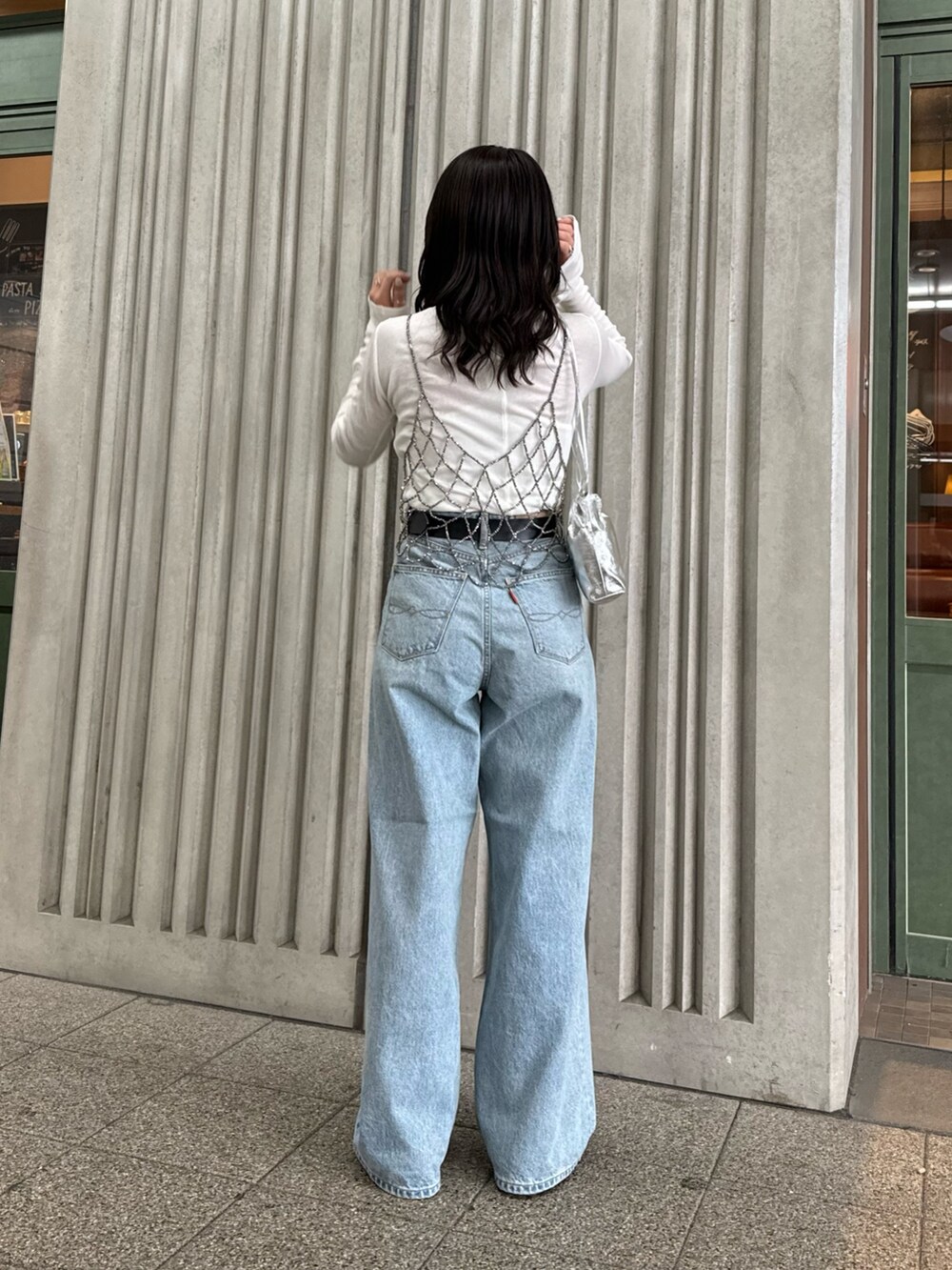 ブラック系のベスト、ブルー系のデニムパンツ、ホワイト系のTシャツ/カットソーを着用したレディースの冬コーディネートの4枚目の写真