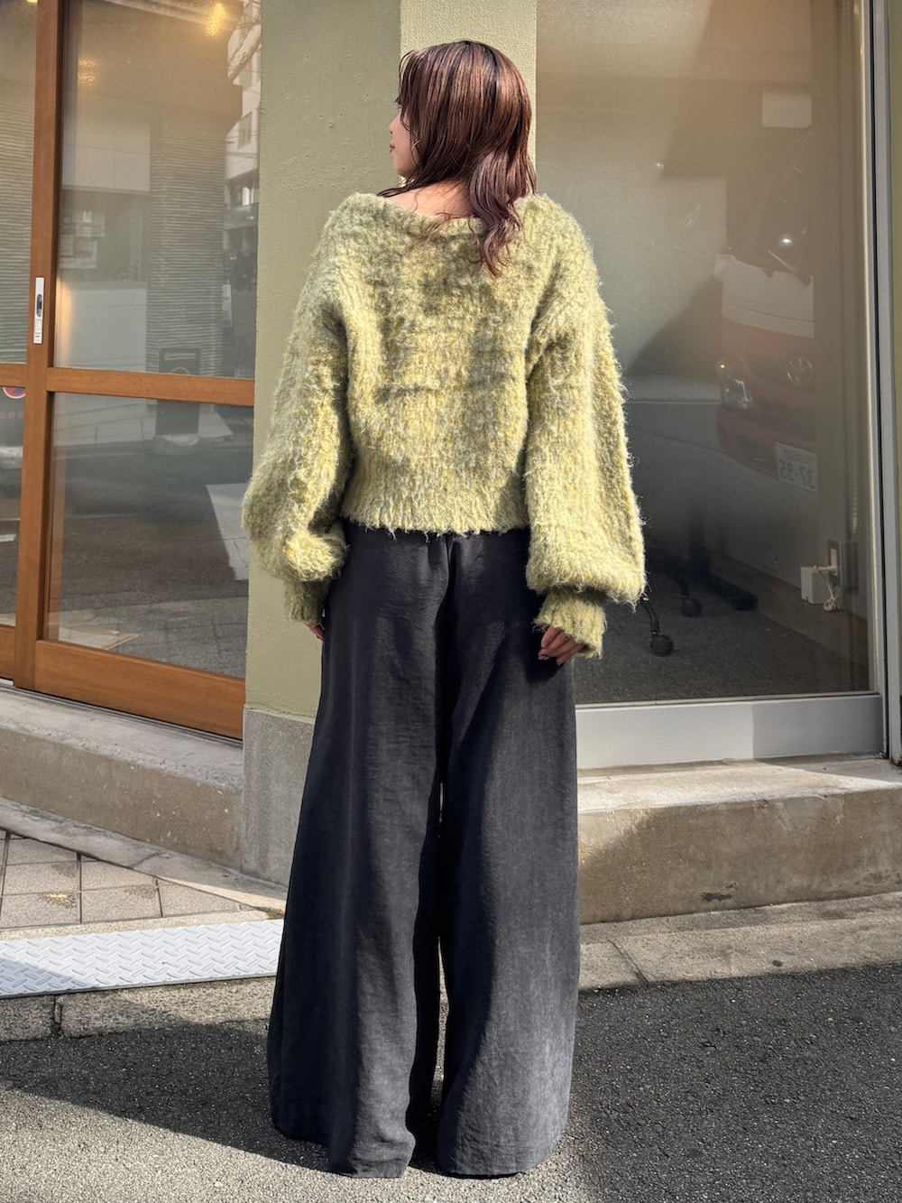 グレー系のその他パンツ、イエロー系のニット/セーターを着用したレディースの秋コーディネートの5枚目の写真
