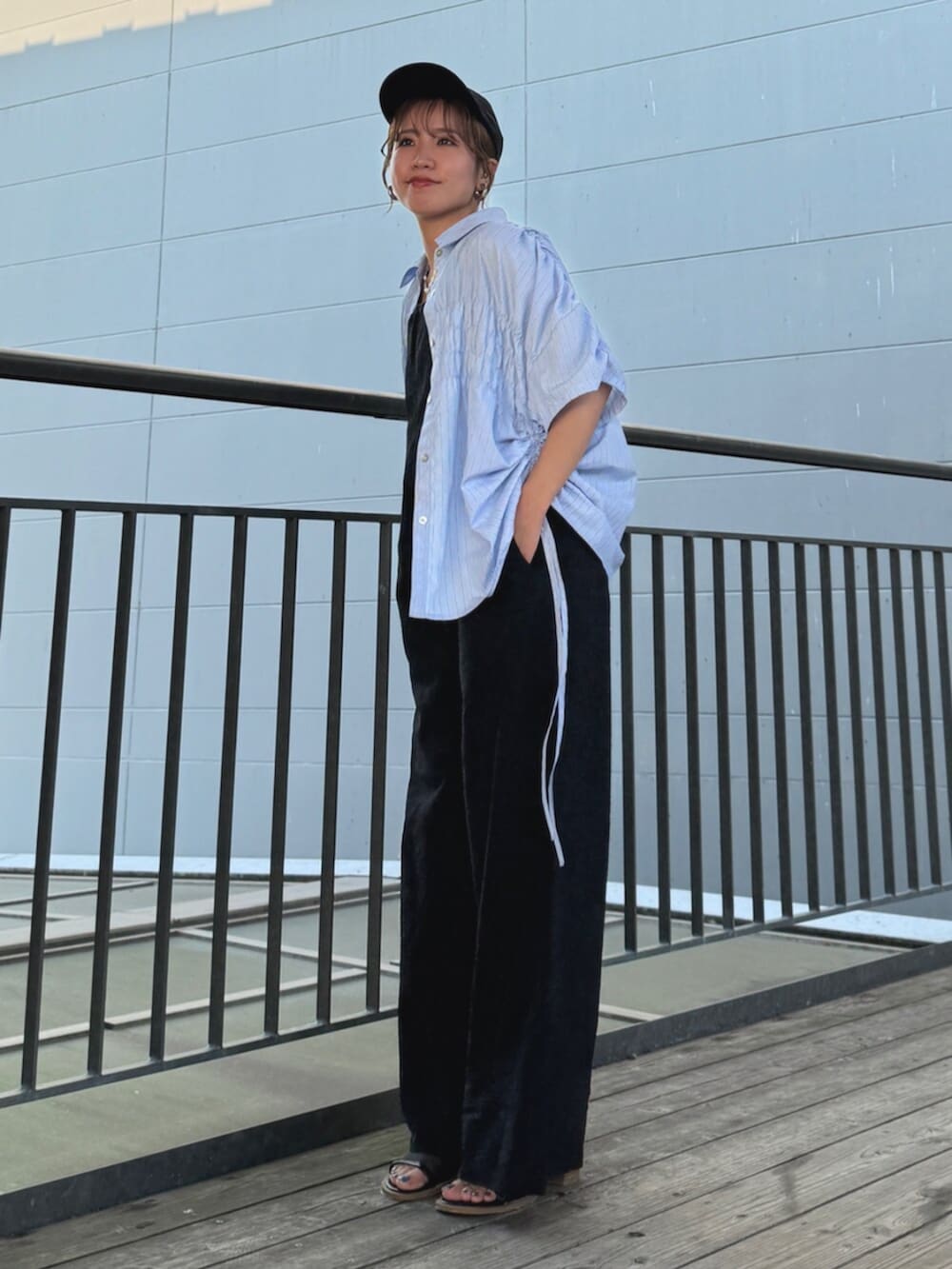 ブラック系のサンダル、ブラック系のサロペット/オーバーオール、ブルー系のシャツ/ブラウスを着用したレディースの夏コーディネートの3枚目の写真