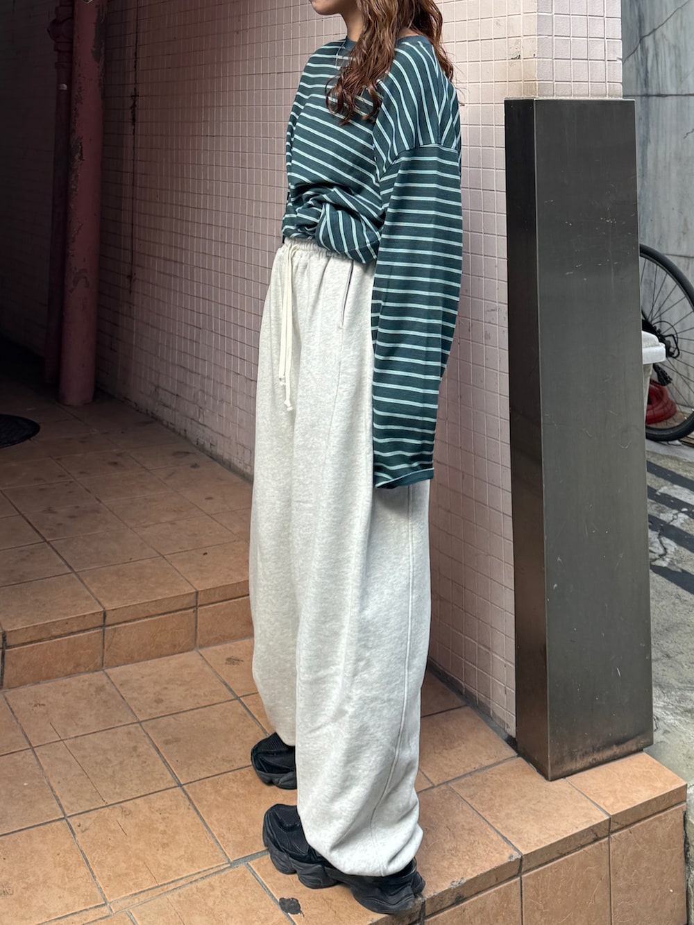 ホワイト系のスウェットパンツ、グリーン系のTシャツ/カットソーを着用したレディースの冬コーディネートの6枚目の写真