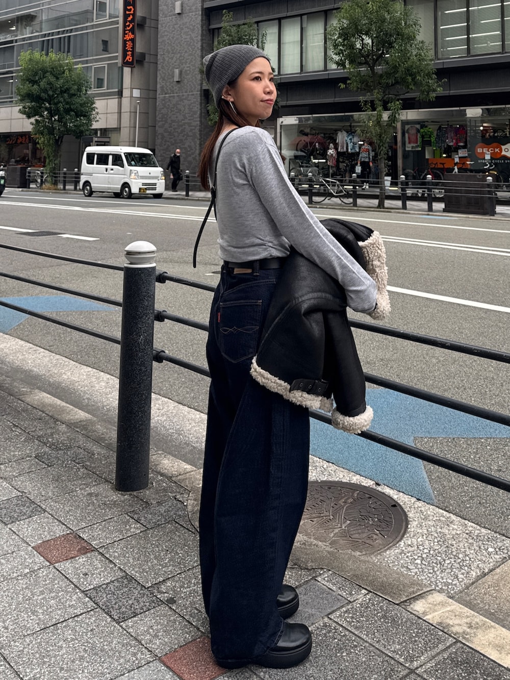 グレー系のニット/セーター、ブルー系のデニムパンツ、グレー系のニットキャップ/ビーニーを着用したレディースの秋コーディネートの3枚目の写真