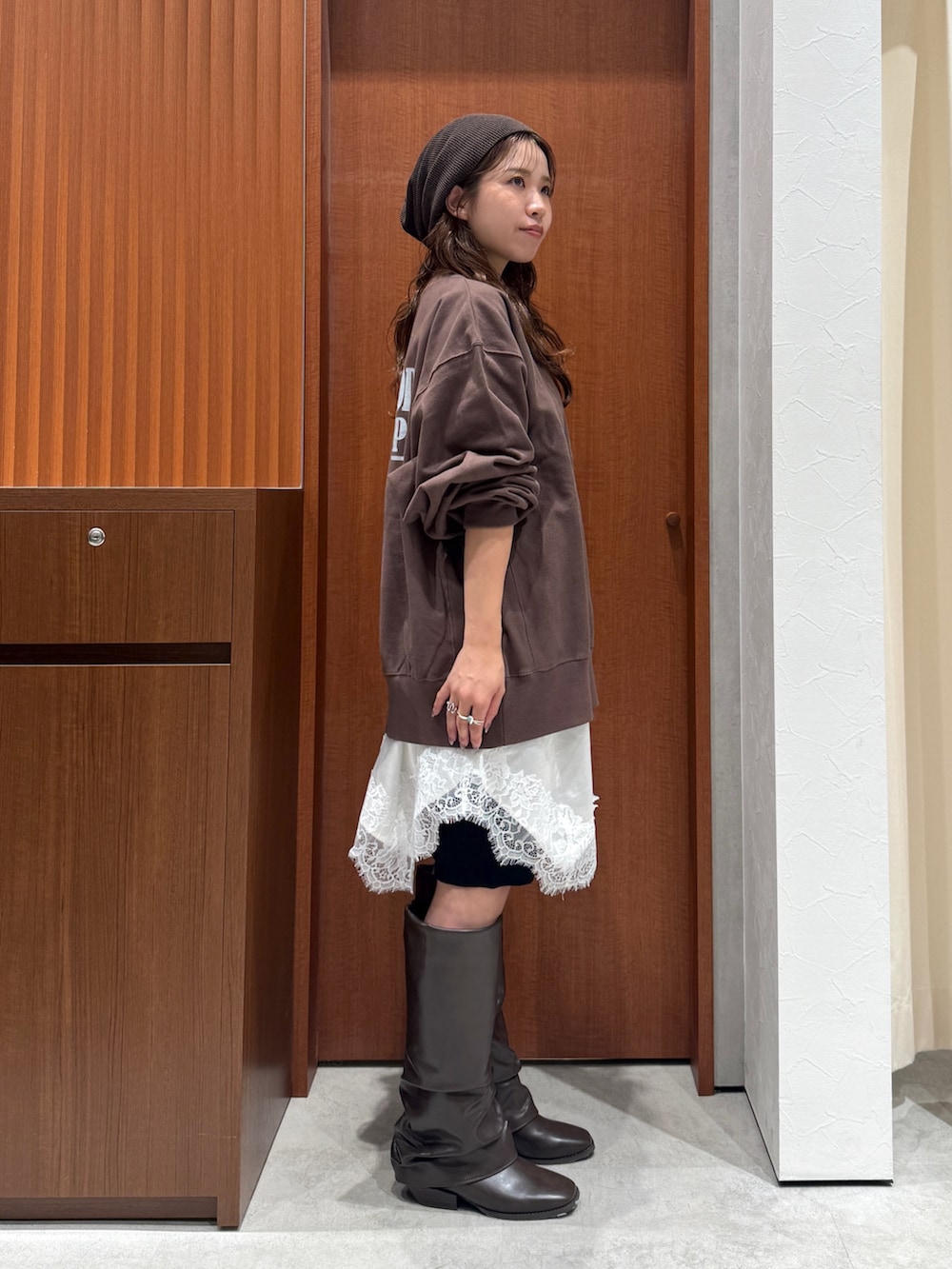 ブラウン系のスウェット、ホワイト系のワンピース、ブラック系のその他パンツを着用したレディースの秋コーディネートの3枚目の写真