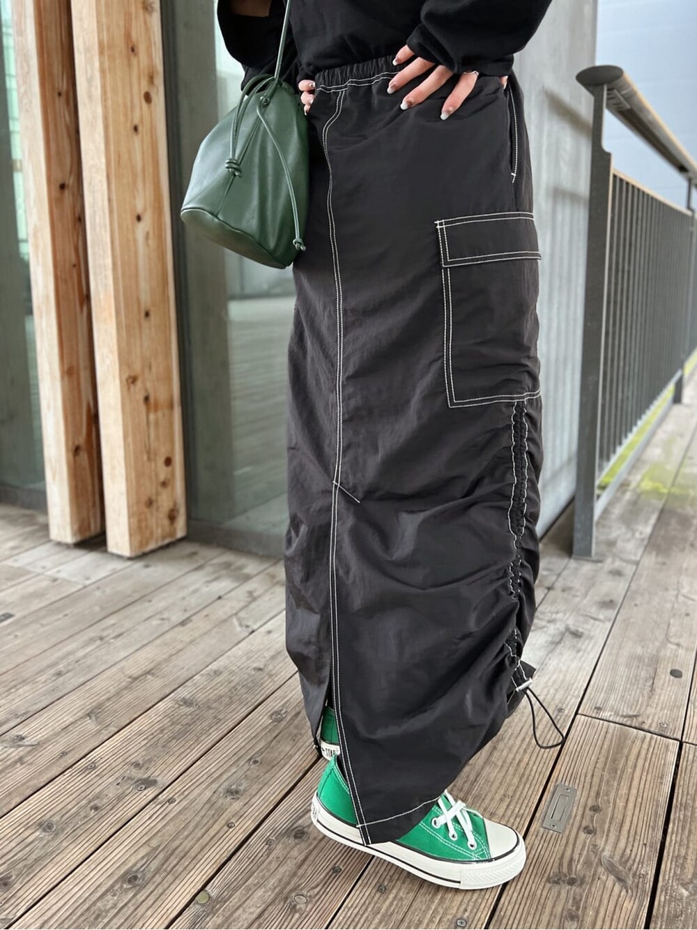 グリーン系のハンドバッグ、ブラック系のTシャツ/カットソー、ブラック系のスカートを着用したレディースの夏コーディネートの9枚目の写真