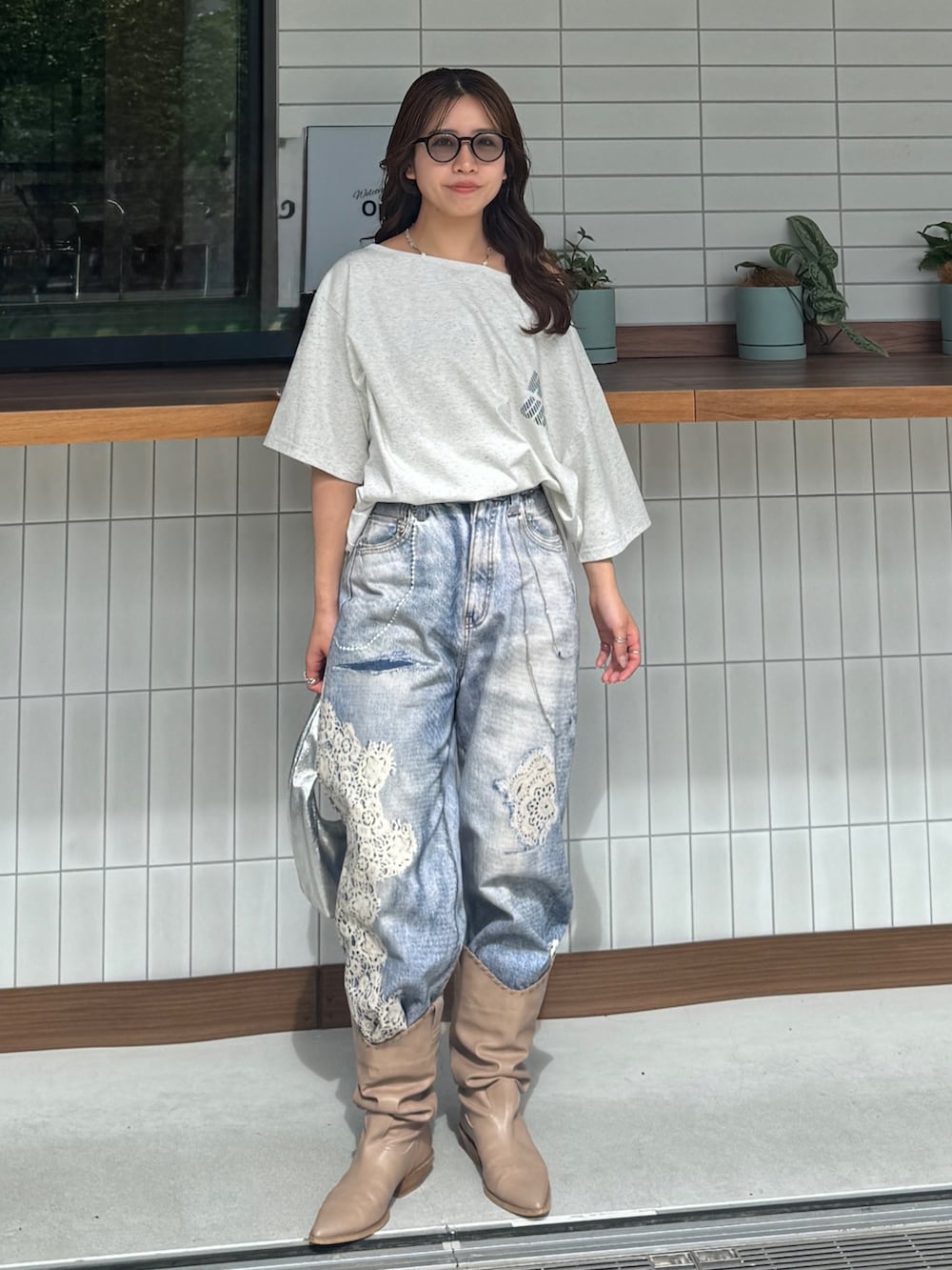 グレー系のTシャツ/カットソー、ブルー系のデニムパンツ、ベージュ系のブーツを着用したレディースの春コーディネートの2枚目の写真