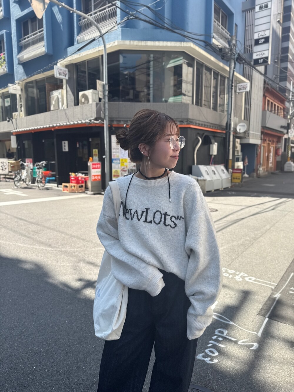 ブルー系のデニムパンツ、ホワイト系のニット/セーター、ホワイト系のトートバッグを着用したレディースの夏コーディネートの8枚目の写真