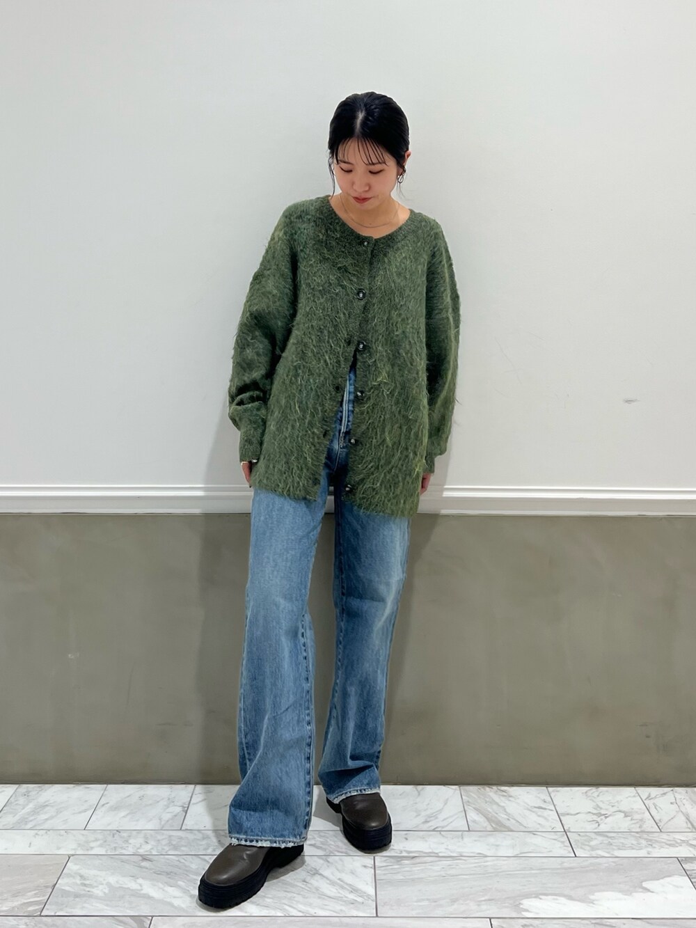 ブルー系のデニムパンツ、グリーン系のカーディガン/ボレロを着用したレディースの秋コーディネートの9枚目の写真